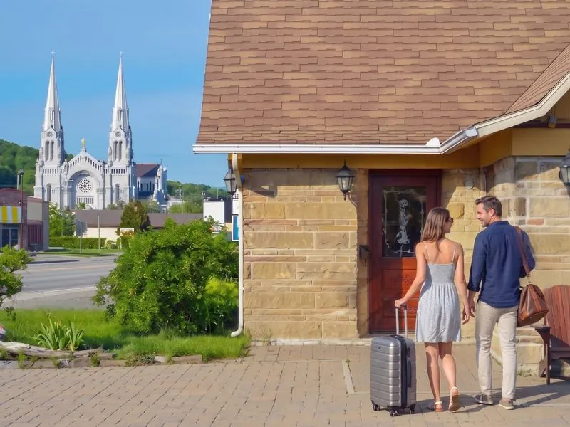 Couple qui arrive à la porte de son studio, avec la basilique Sainte-Anne en arrière-plan